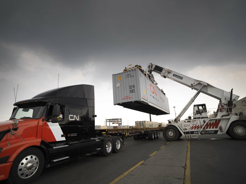 A picture of a CN truck being loaded with a container.