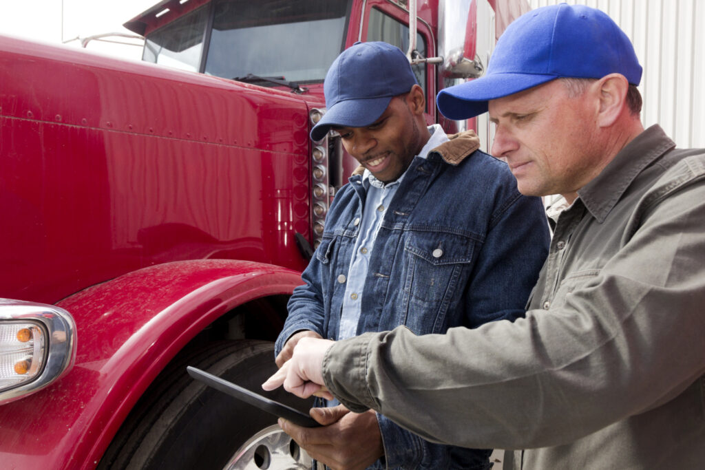 (Photo: iStock) Men standing in front of a truck looking at a tablet