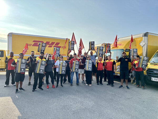 汉密尔顿集会上的Unifor成员。(照片:Unifor) 在汉密尔顿举行的有组织的集会上,Unifor成员手持标语和旗帜,站在带有DHL品牌标志的卡车前。