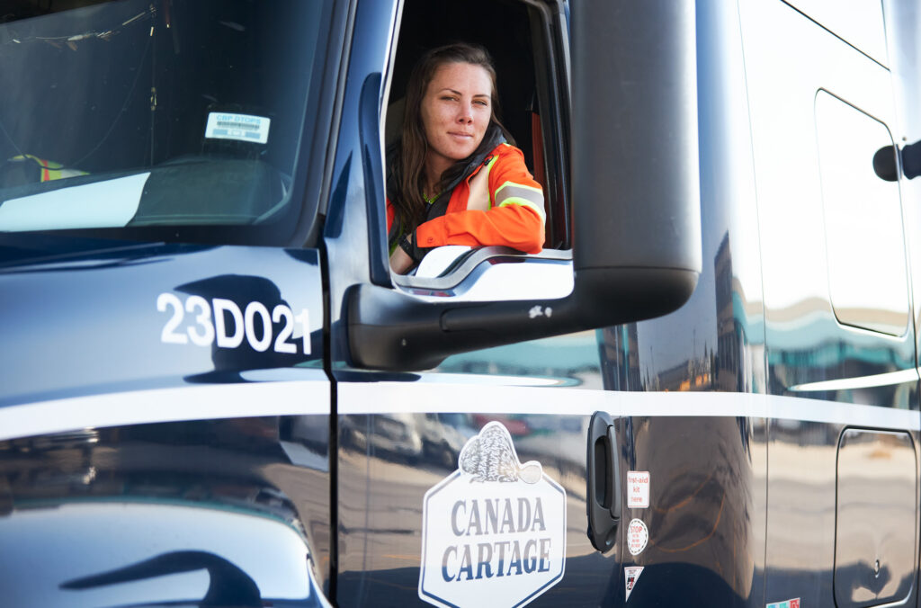 Picture of a woman in the cab of a Canada Cartage truck.