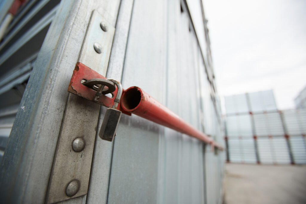 Close-up of sealed metal shipping container, hanging open lock after burglary