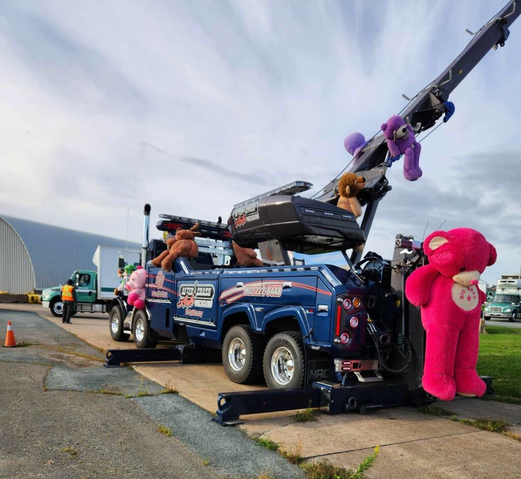 Big truck at the convoy with multiple human-sized teddy bears attached to it